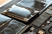 Swollen battery of broken laptop in open casing closeup