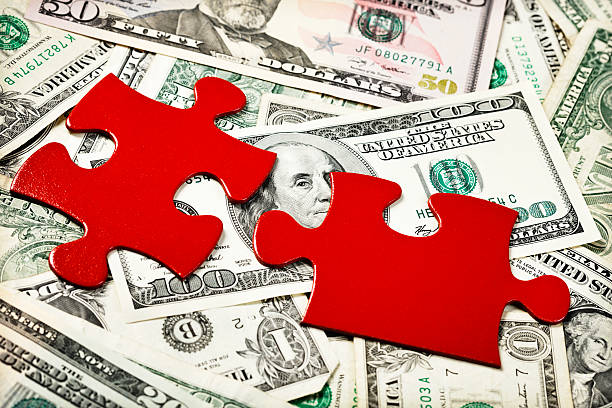 istock Solving the financial puzzle: red jigsaw pieces on dollar background 184651177