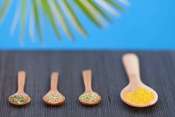 "closed up of spoons with dried herbage and curry salt in tropical ambience,selective focus, more of this shooting"