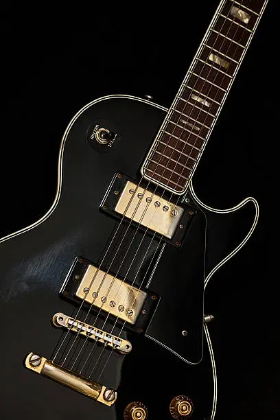 Vintage generic Japanese ebony electric guitar with two humbucker pickups and worn out  gold hardware.