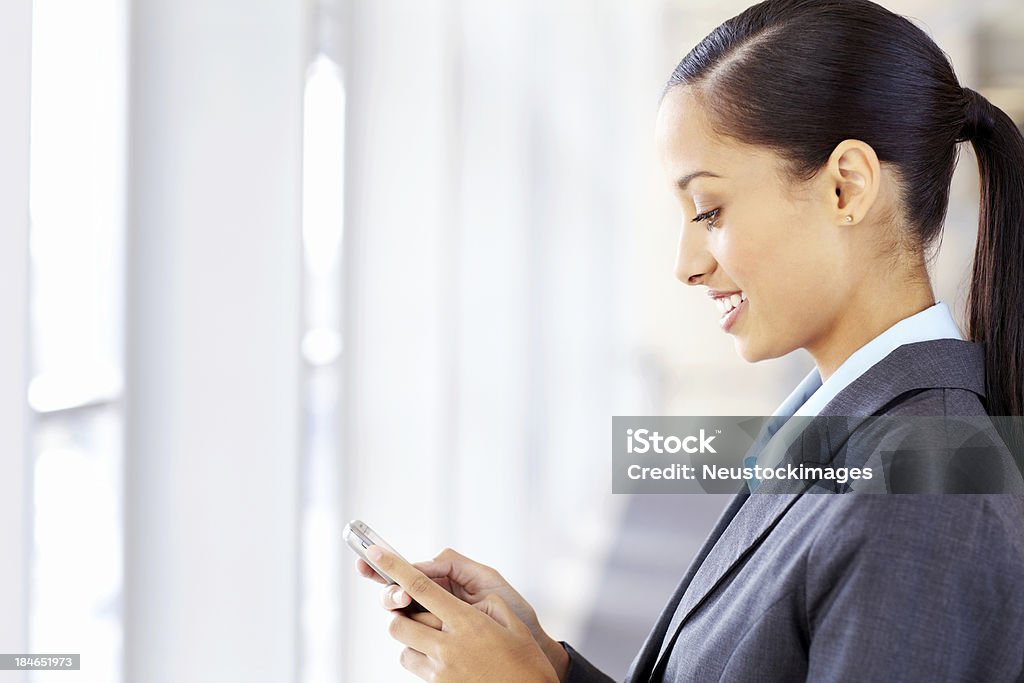 Femme d'affaires à envoyer des SMS sur un téléphone portable - Photo de Adulte libre de droits