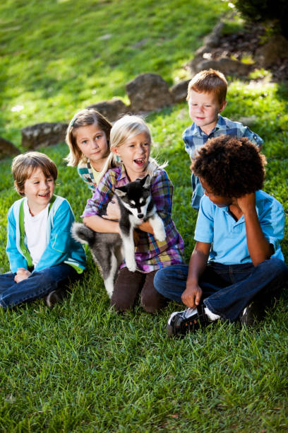 istock Multiracial children holding husky puppy 184652171