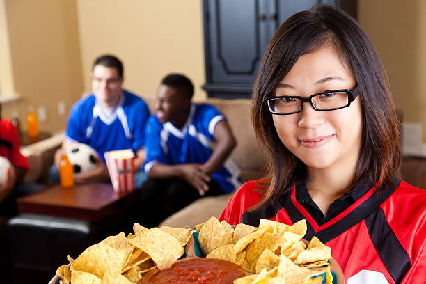 istock Spouse or girlfriend holding snacks for guys watching soccer game 184652363