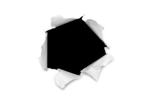 Torn paper hole over black background.