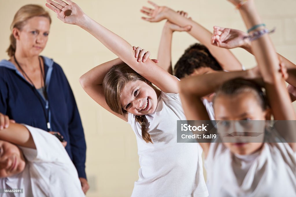 Gruppe von Kindern in Klasse Dehnung im College-Sport-Look - Lizenzfrei Afro-amerikanischer Herkunft Stock-Foto