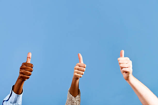istock Three enthusiastic thumbs up against sky blue 184652666