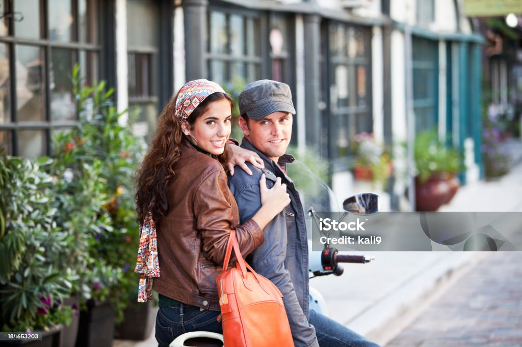 Jovem casal andando na rua de paralelepípedos de scooter - Foto de stock de Adolescentes Meninas royalty-free