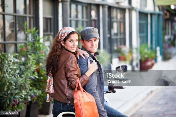 Casal Jovem Dirigindo Lambreta De Paralelepípedo Street - Fotografias de stock e mais imagens de Bicicleta Motorizada