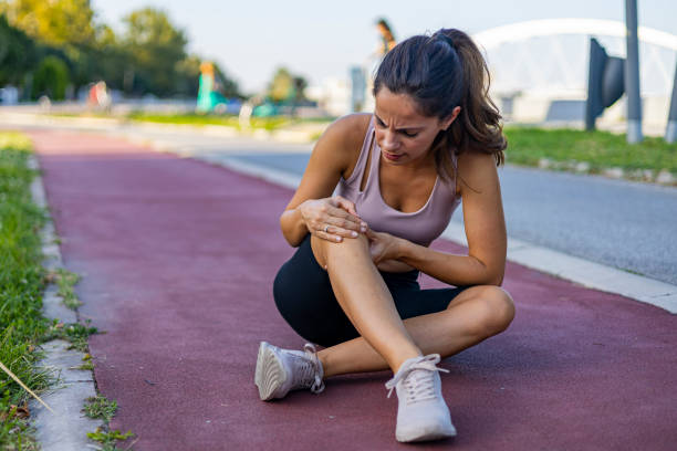 Young woman feeling pain in her knee.
