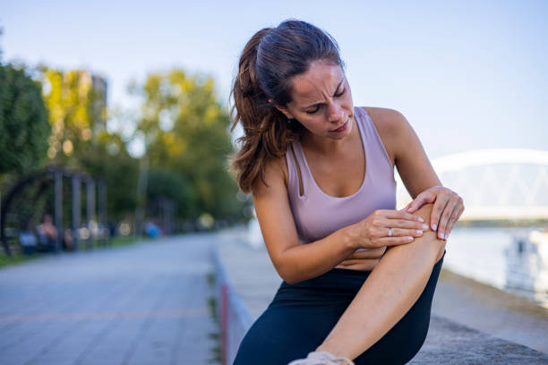 istock Woman sitting on ground and holding knee 1846536435