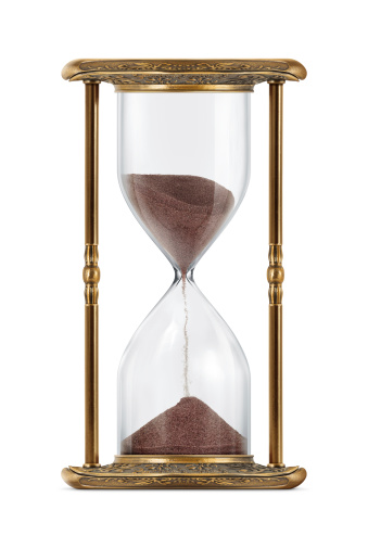 An ancient looking hourglass isolated on white background.