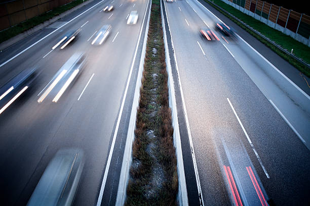 German autobahn - view from a bridge "German autobahn - view from a bridge at dusk, motion blur" autobahn stock pictures, royalty-free photos & images