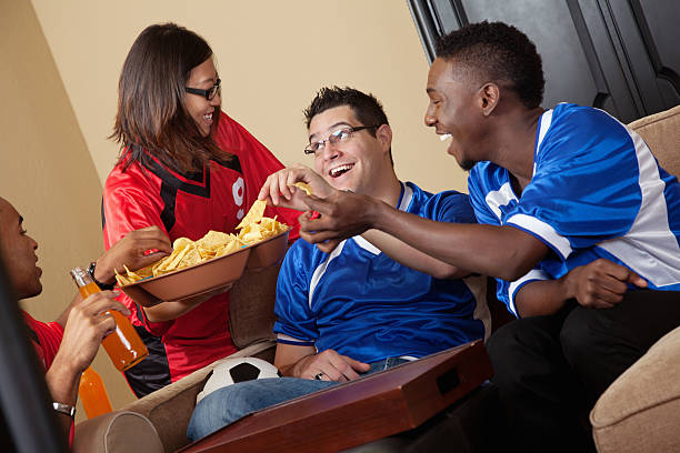 istock Friends enjoying snacks during soccer game TV watching party 184654480