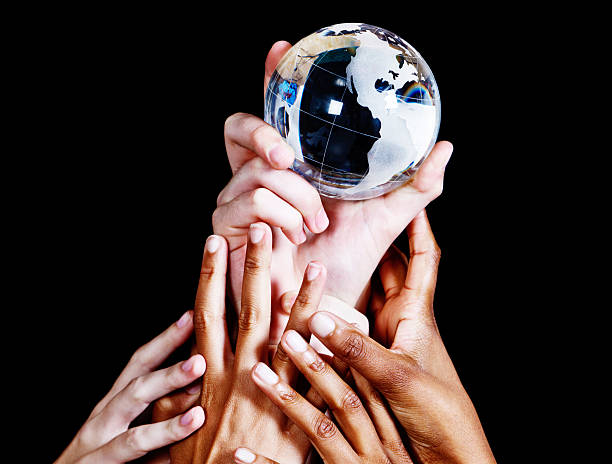 istock Many hands compete for crystal globe against black background 184654759