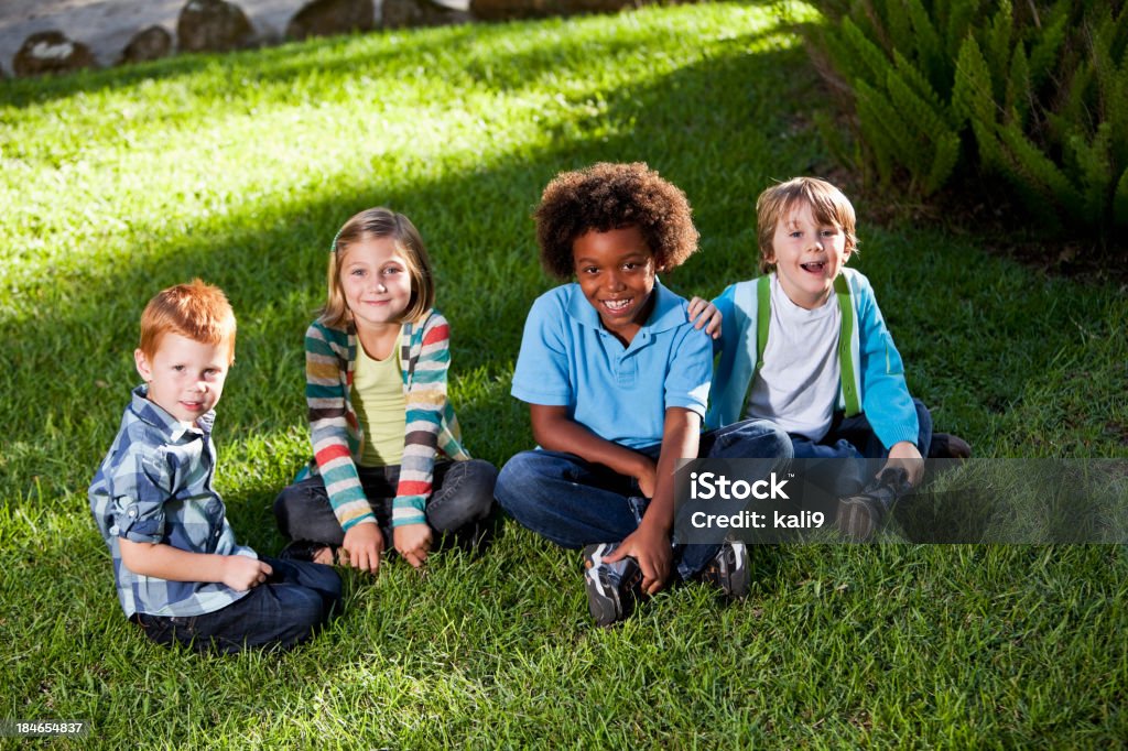 Multirracial niños sentados sobre la hierba - Foto de stock de 2-3 años libre de derechos