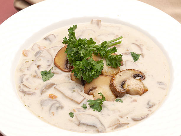 Shitake mushroom sauce in a bowl with fresh mushrooms on a white background