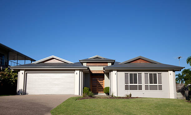 istock Front of modern home with green grass and blue sky 184654989