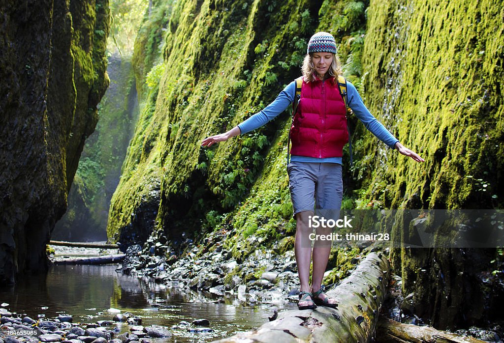 Woman hiking in Canyon "A woman crosses a log in a deep lush canyon. Oneonta Gorge, Columbia Gorge National Scenic Area, Oregon." Balance Stock Photo