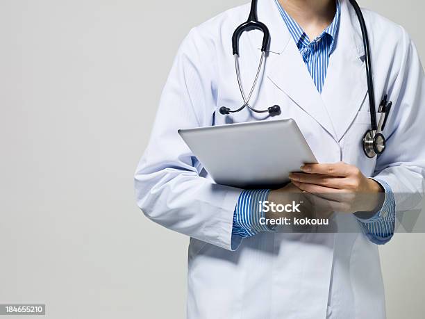 Medici Esaminata Utilizzando Il Telefono Cellulare Tablet Pc - Fotografie stock e altre immagini di Accudire