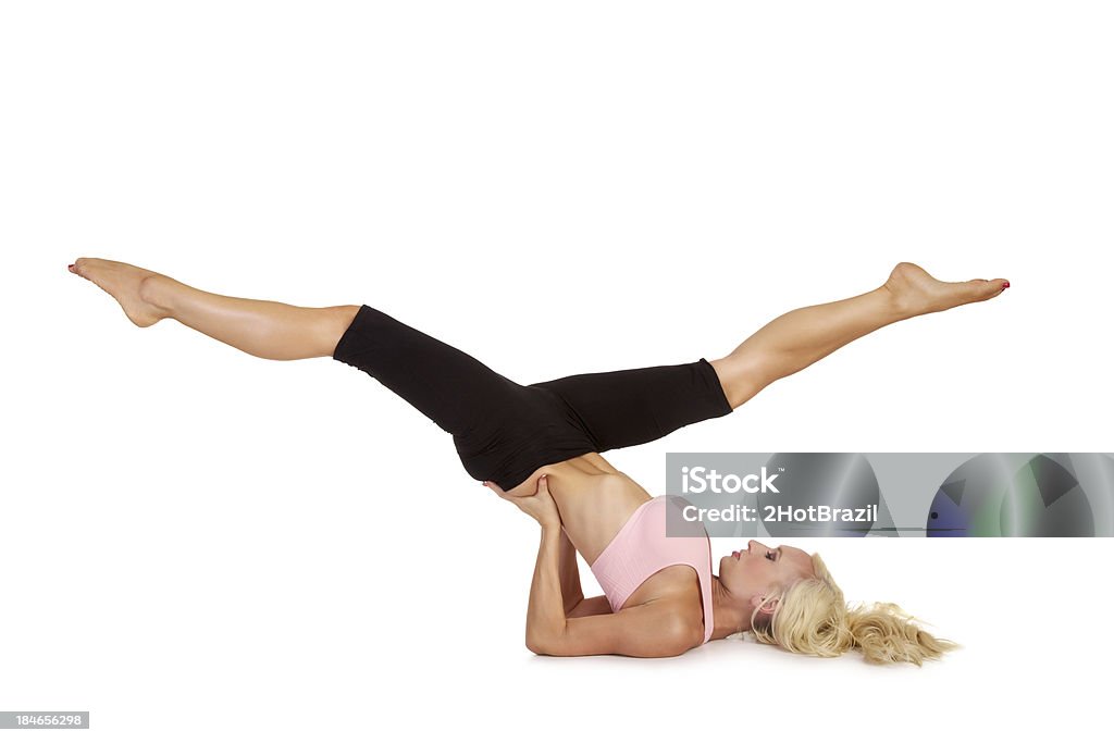 Young Woman Practicing Pilates - Isolated Young Woman Practicing Pilates-a scissors exercise. Isolated on white Activity Stock Photo
