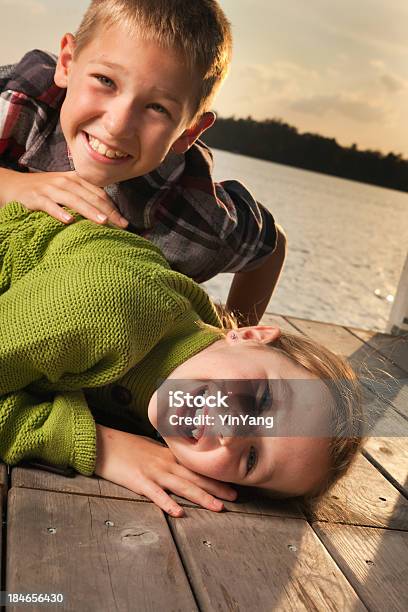 Crianças Brincando Na Costa Do Lago Doca Ao Pôr Do Sol - Fotografias de stock e mais imagens de 8-9 Anos