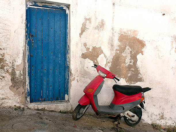 istock Red Scooter parked outside old blue door, Mykonos, Greece 184657940