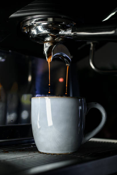 istock Hot fresh coffee pours from professional coffee machine to ceramic gray cup, close up view 1846581998