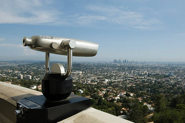 Looking at Los Angeles A telescope viewer overlooks this aerial view of the Los Angeles skyline. griffith park observatory stock pictures, royalty-free photos & images