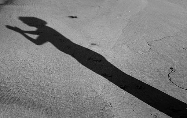 istock Shadow of a Womans Yoga Pose on the Beach 184659058