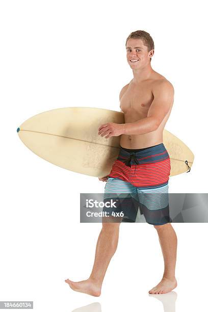 Foto de Homem Andando Com Uma Prancha De Surfe e mais fotos de stock de Andar - Andar, Corpo inteiro, Figura para recortar