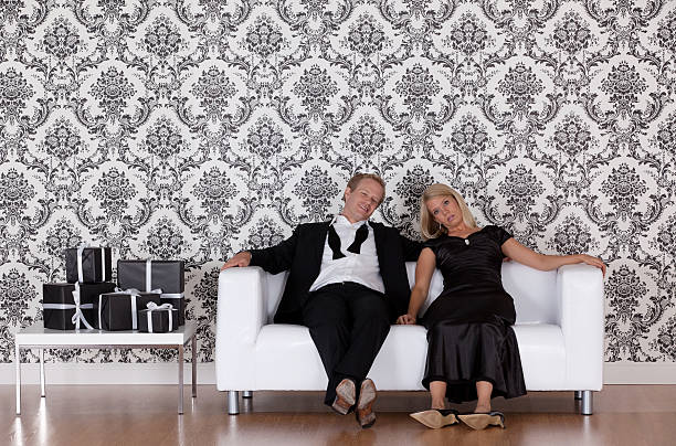 Tired couple sitting on couch after party