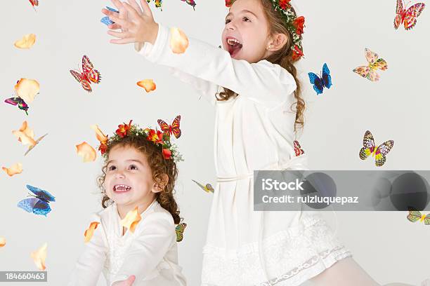 Photo libre de droit de Charmante Sœurs Jouant Avec Des Fleurs Et Des Papillons banque d'images et plus d'images libres de droit de Enfant