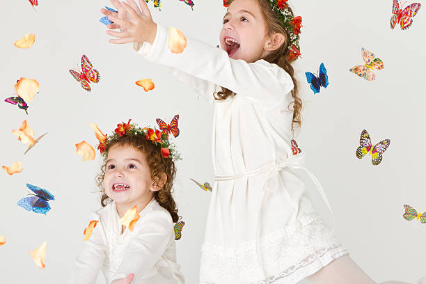istock Lovely sisters playing with petals and butterflies 184660463