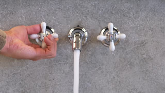 Mans hand turn off water tap after hygienic procedures.
