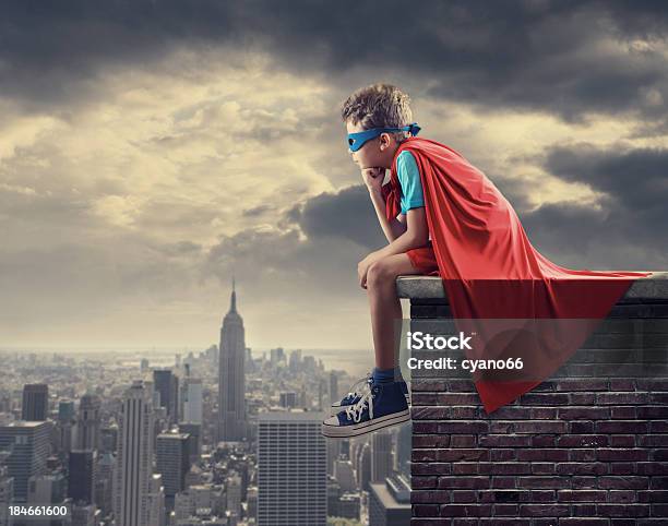 Foto de Pouco De Superherói Sentado Em Cima Da Muro e mais fotos de stock de Super-herói - Super-herói, Criança, Sentar