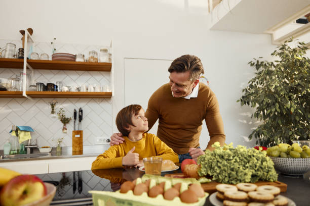 istock Happy father talking to his small son in the kitchen. 1846624047