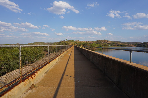 On top of Lake Moondarra Dam, with an abstract pattern of sun and shade, Lake Moondarra, Mt Isa, Queensland, Australia