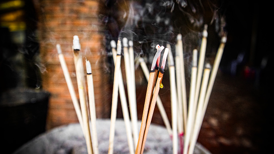 Putting incense sticks into cauldron