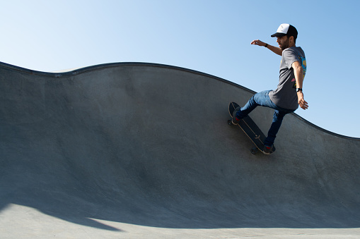 Venice Beach, United States – October 21, 2013: A young male performing skateboarding at an outdoor skateboard park