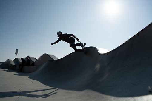 Venice Beach, United States – October 21, 2013: A young male performing skateboarding at an outdoor skateboard park