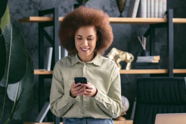 istock Successful confident business woman in office using mobile phone smiling 1846674520