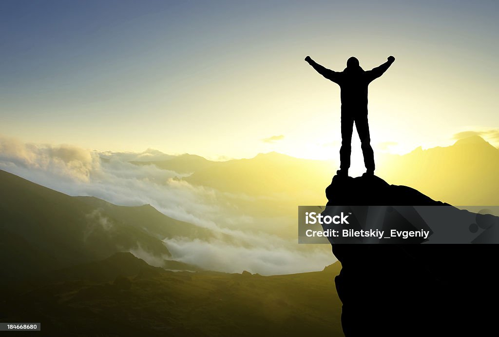 Silhouette of a winner Silhouette of a winner on the rock. Sport and active life concept Activity Stock Photo