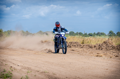 An Enduro bike racer driving on dirt motocross dust track
