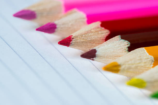 Line of coloured pencils - red pencil in focus stock photo