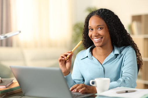 Black tele worker eating cereal stick posing at home