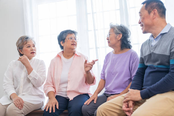 senior females and male sitting on bench. older people are listening and enjoy meeting focus group at living room. joyful carefree retired senior friends enjoying relaxation at nearly home. - senior adult human face male action imagens e fotografias de stock