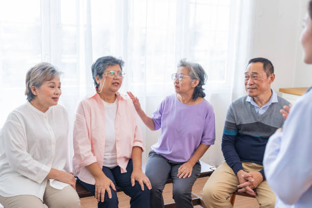 senior females and male sitting on bench. older people are listening and enjoy meeting focus group at living room. joyful carefree retired senior friends enjoying relaxation at nearly home. - senior adult human face male action imagens e fotografias de stock