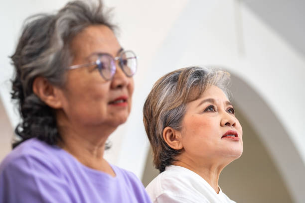 close up senior females and male sitting on bench. older people are listening and enjoy meeting focus group at living room. joyful carefree retired senior friends enjoying relaxation at nearly home. - senior adult human face male action imagens e fotografias de stock