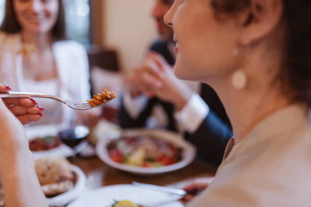 People, Food and Leisure Concept - Close Up of Female With Fork Eating Dinner at Restaurant