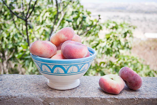 Bowl of flat peaches stock photo